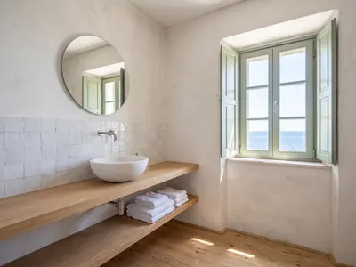 Example apartment: bathroom with a wooden shelf, a basin and a round mirror