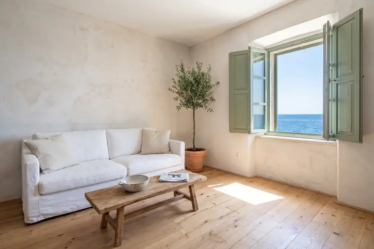 Example apartment: living room with a white sofa and a window to the sea