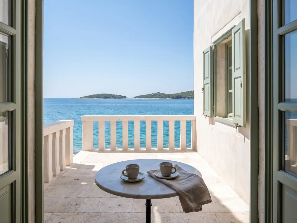 Example apartment: terrace with a round table, two cups and a sea view