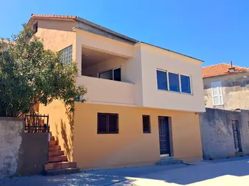 Apartment photo: house with a yellow ground floor and a balcony upstairs