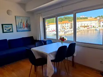 Apartment photo: living room with a blue sofa and a table, harbour in the window