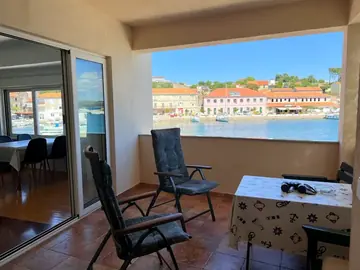 Apartment photo: terrace with chairs and a view of the seaside village