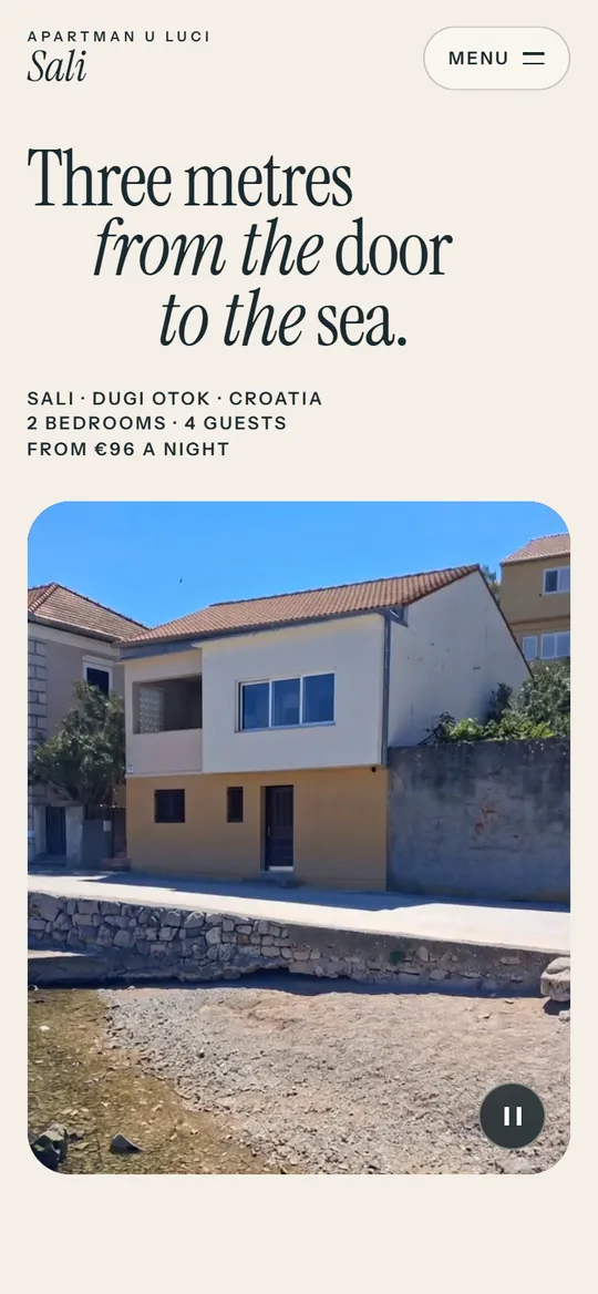 The Apartman u luci Sali website on a phone: the headline “Three metres from the door to the sea” and a photo of the house on the waterfront.